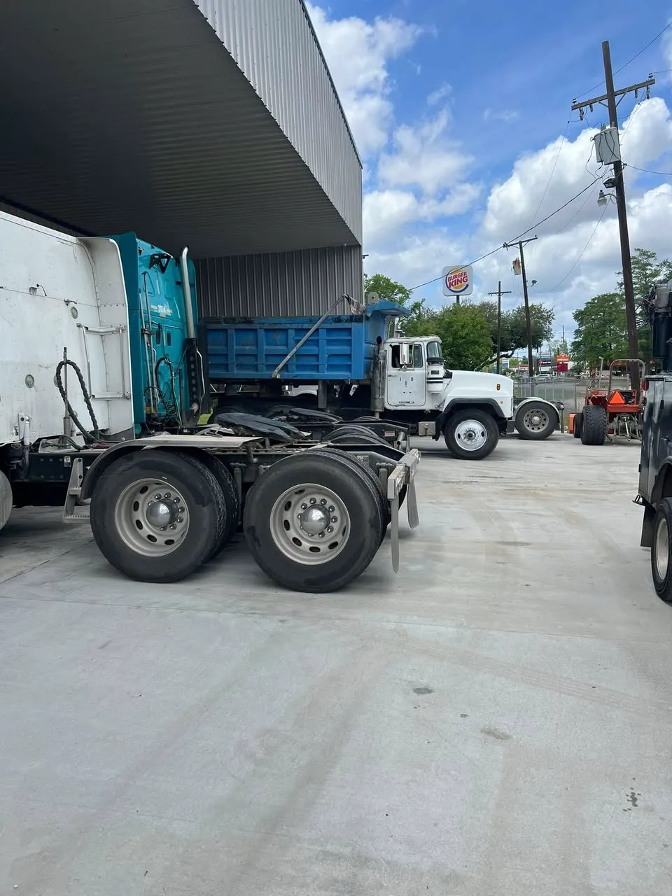 Mack dump trucks staged outside the shop for service